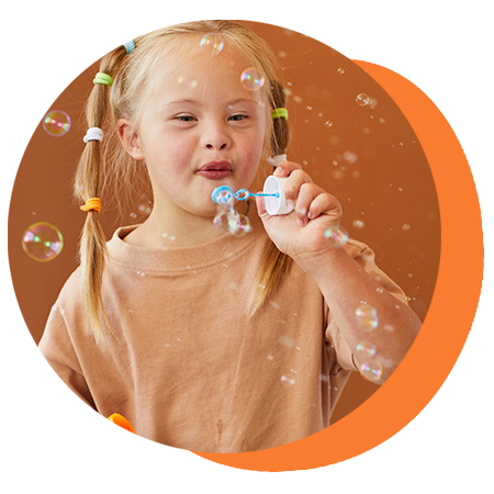 Child blowing bubbles with a blue wand against an orange background