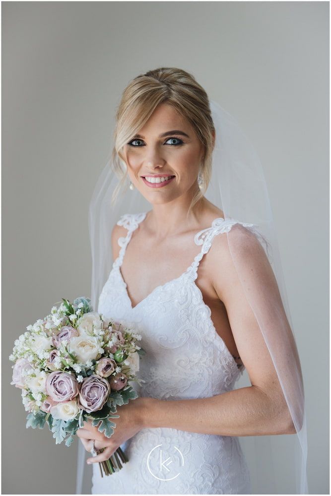 A Bride in a White Dress and Veil is Holding a Bouquet of Flowers — Just Formals in Winnellie, NT