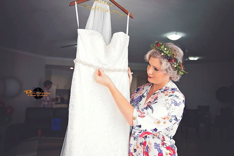 A Woman is Holding a Wedding Dress Hanging on a Hanger — Just Formals in Winnellie, NT