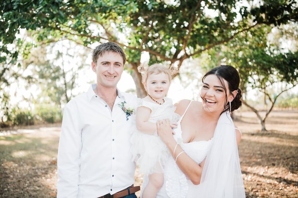 A Bride and Groom Are Posing for a Picture With Their Daughter — Just Formals in Winnellie, NT