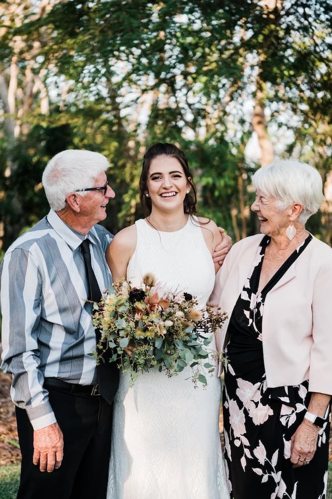 A Bride is Posing for a Picture With Her Parents on Her Wedding Day — Just Formals in Winnellie, NT