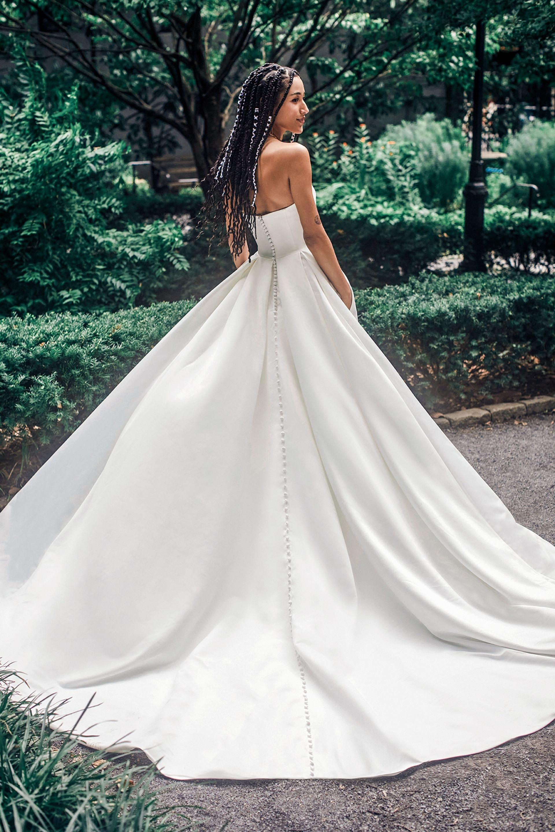 A Woman in a Flowing White Wedding Dress Stands Outdoors — Just Formals in Winnellie, NT