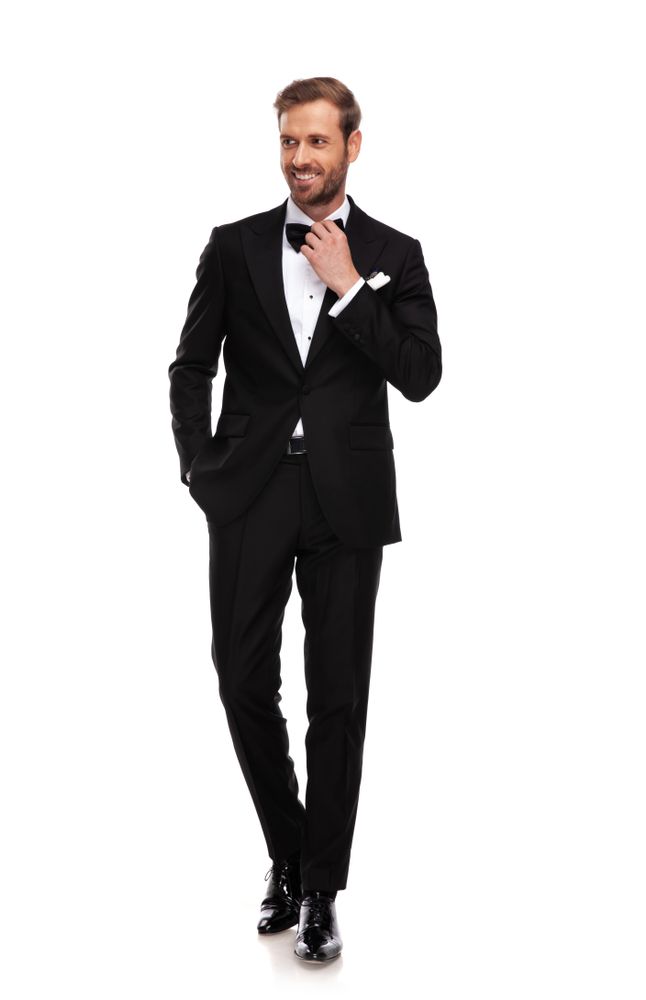 Man in a Black Tuxedo Adjusting His Bow Tie — Just Formals in Winnellie, NT