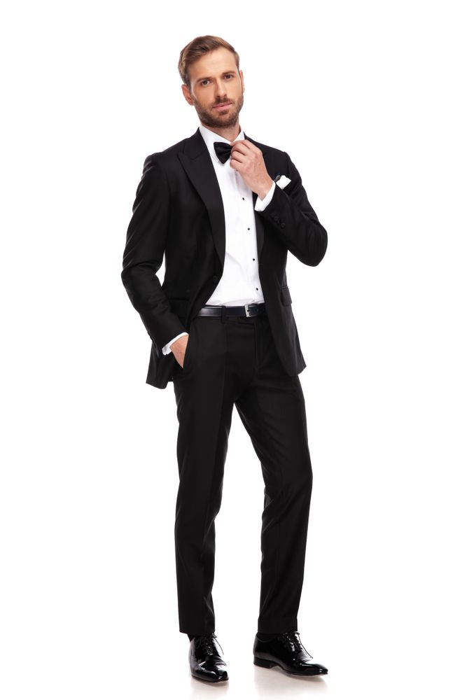 Man in Black Tuxedo Adjusting Bow Tie — Just Formals in Winnellie, NT