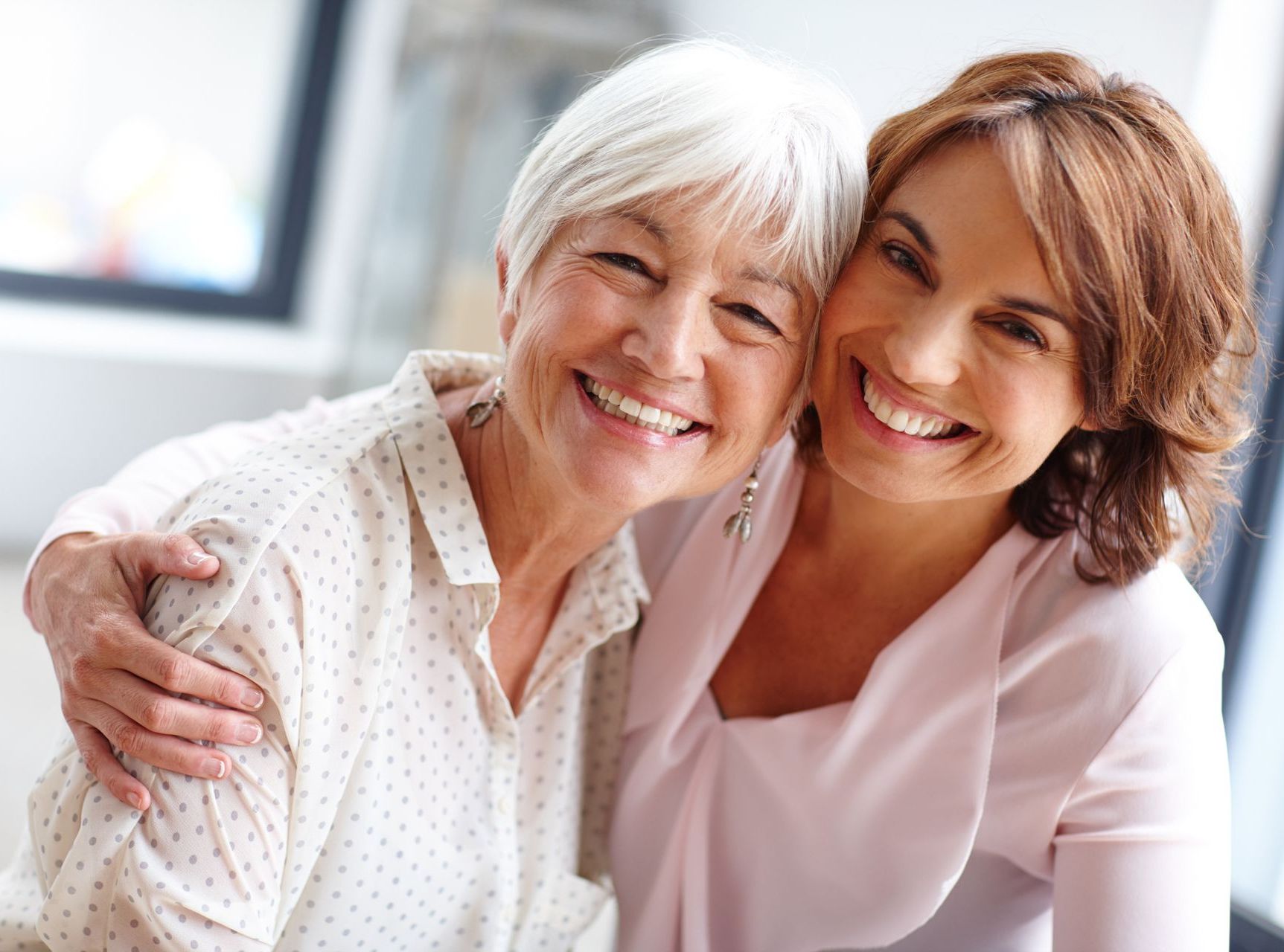 Two women are hugging each other and smiling for the camera.