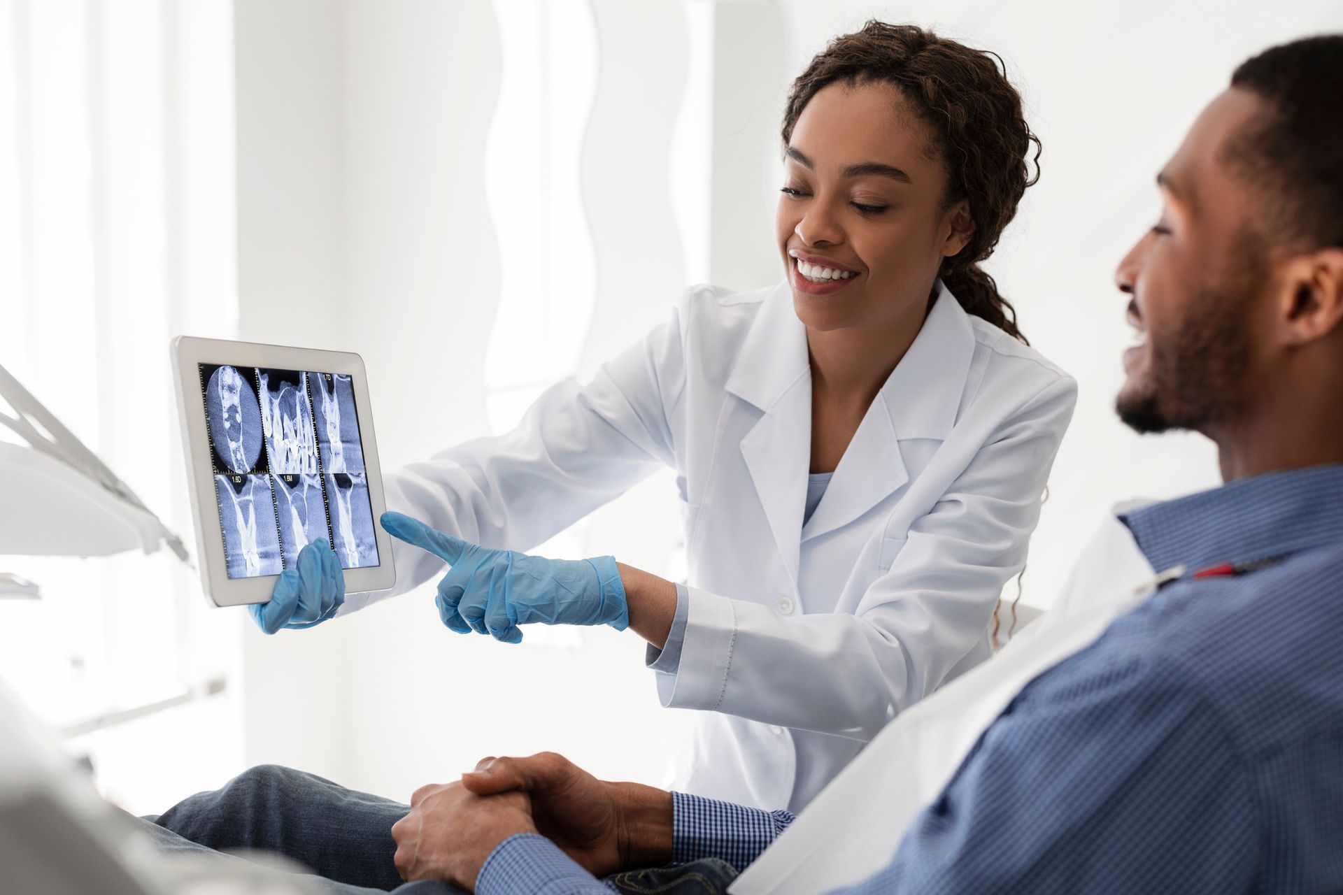 A dentist is showing a patient an x-ray of his teeth.