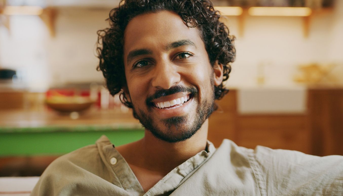 A man with a beard is smiling and looking at the camera.