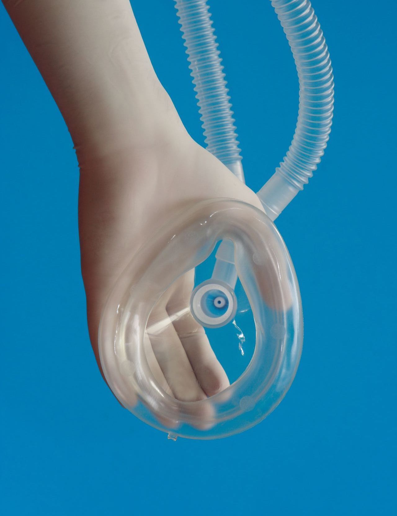 A person is wearing an oxygen mask with a hose attached to it.