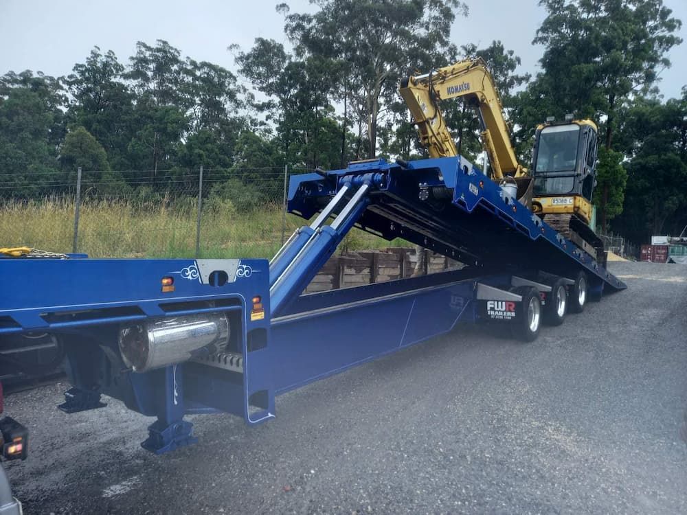Excavator Being Placed Onto a Truck — Port Macquarie Tilt Tray Towing in Telegraph Point, NSW