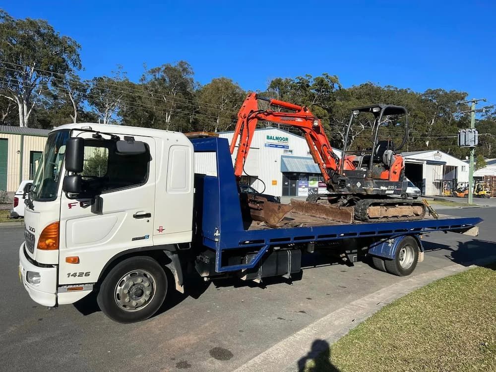 Orange Coloured Mini Excavator Loaded on a Tow Truck — Port Macquarie Tilt Tray Towing in Wauchope, NSW