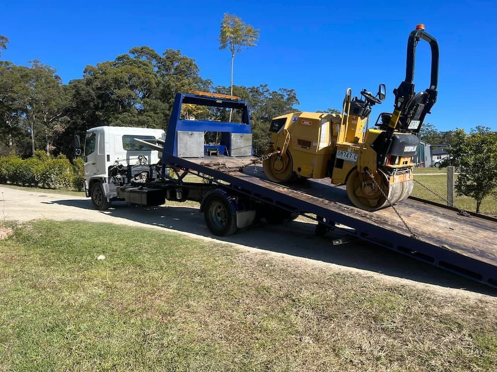 Heavy Equipment Safely Fastened Onto the Truck — Port Macquarie Tilt Tray Towing in Telegraph Point, NSW
