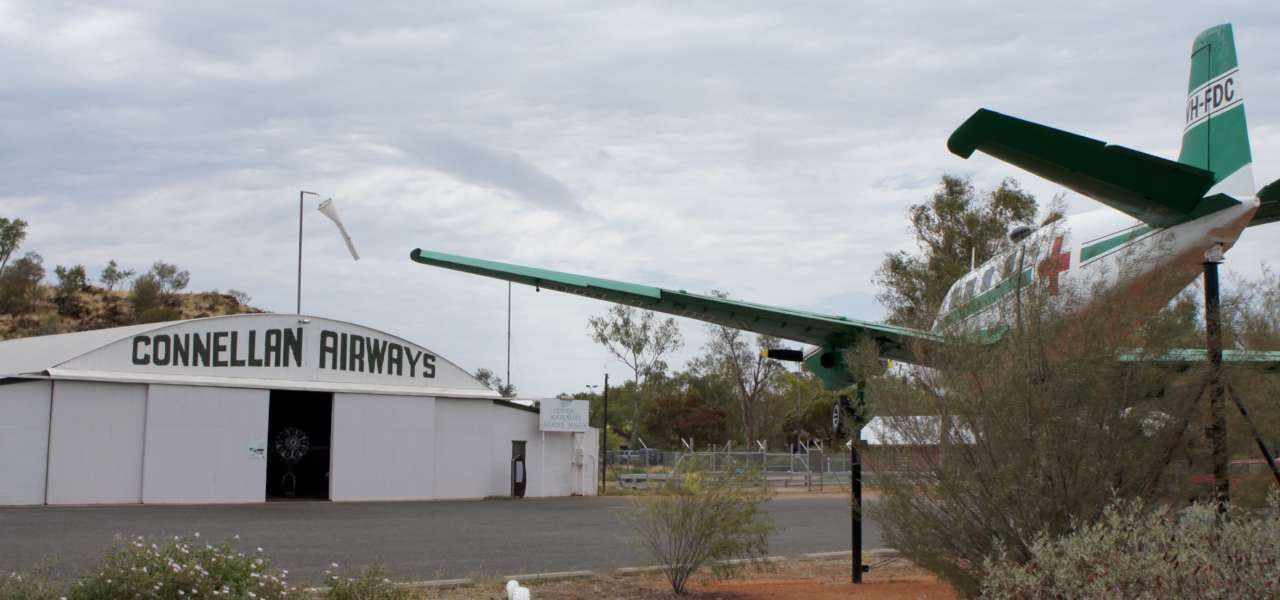 A plane is parked in front of a building that says connellan airways