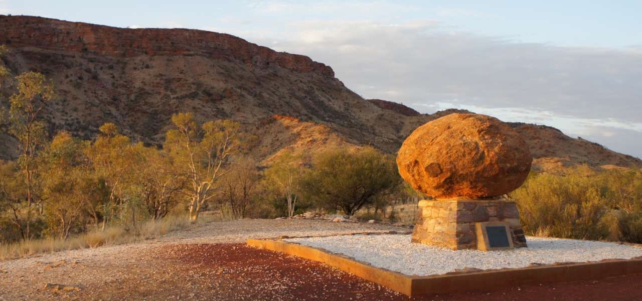 There is a large rock in the middle of the desert.