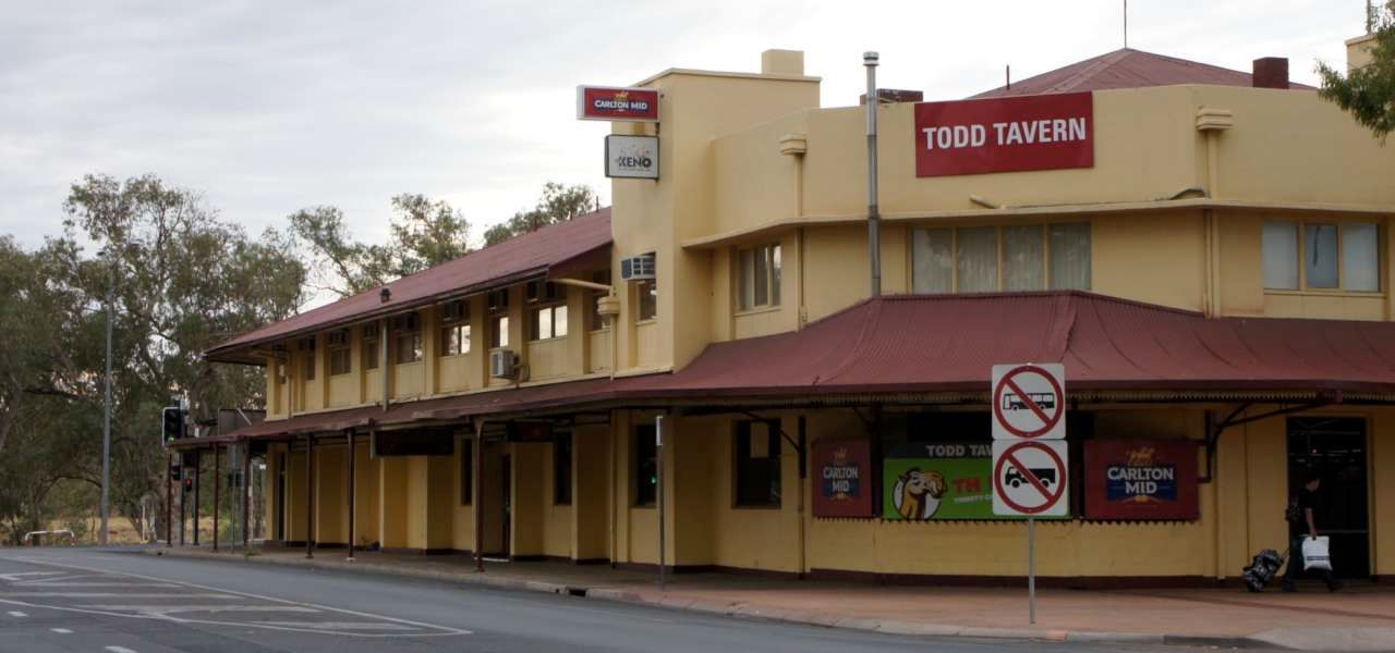A yellow building with a red roof and a sign that says food tavern