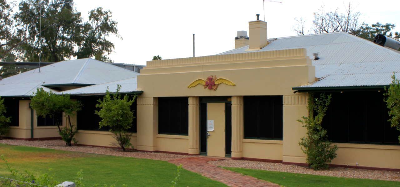 A house with a white roof and a red emblem on the front