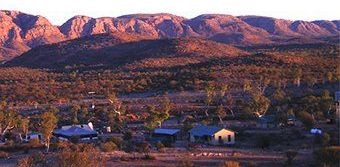 A small town in the middle of a desert with mountains in the background.