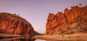 There is a river between two rocky cliffs in the desert.