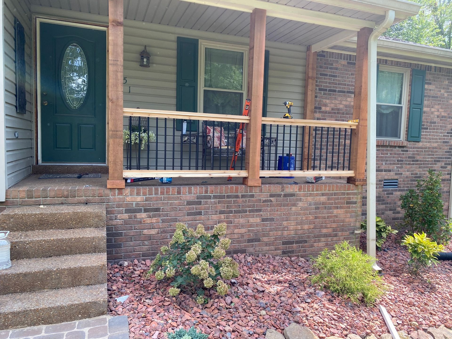 The front porch of a house with a wooden railing and stairs.