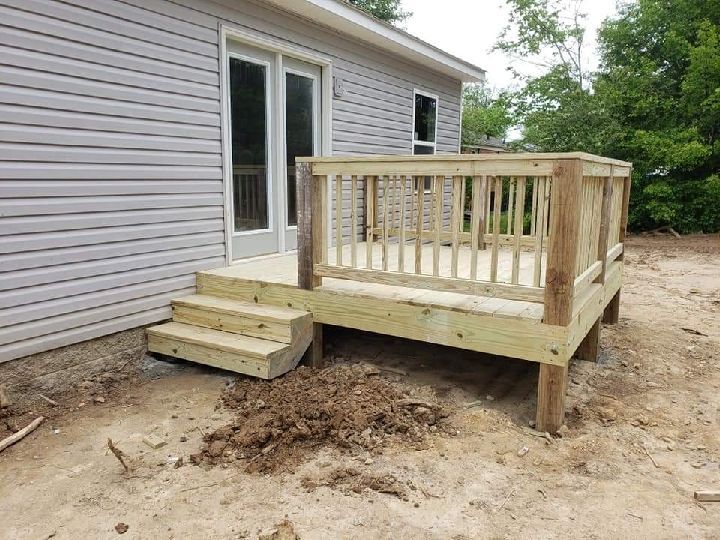 A wooden deck is being built in front of a house.