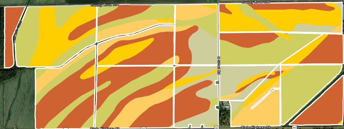 A soil map shows irregular color-coded zones in red, orange, yellow, and tan overlaying an agricultural field grid.