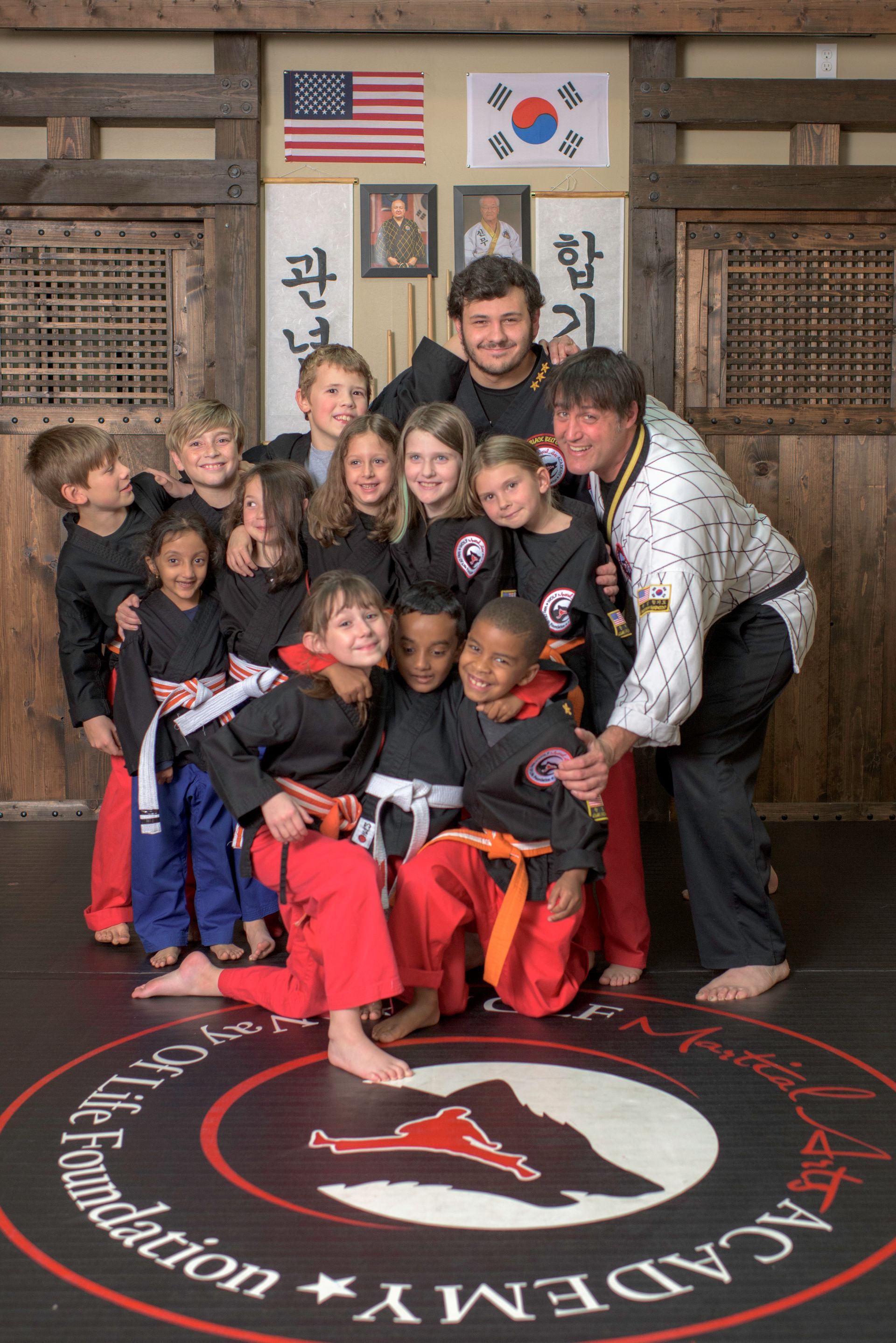 A group of kids posing for a picture in front of a sign that says academy