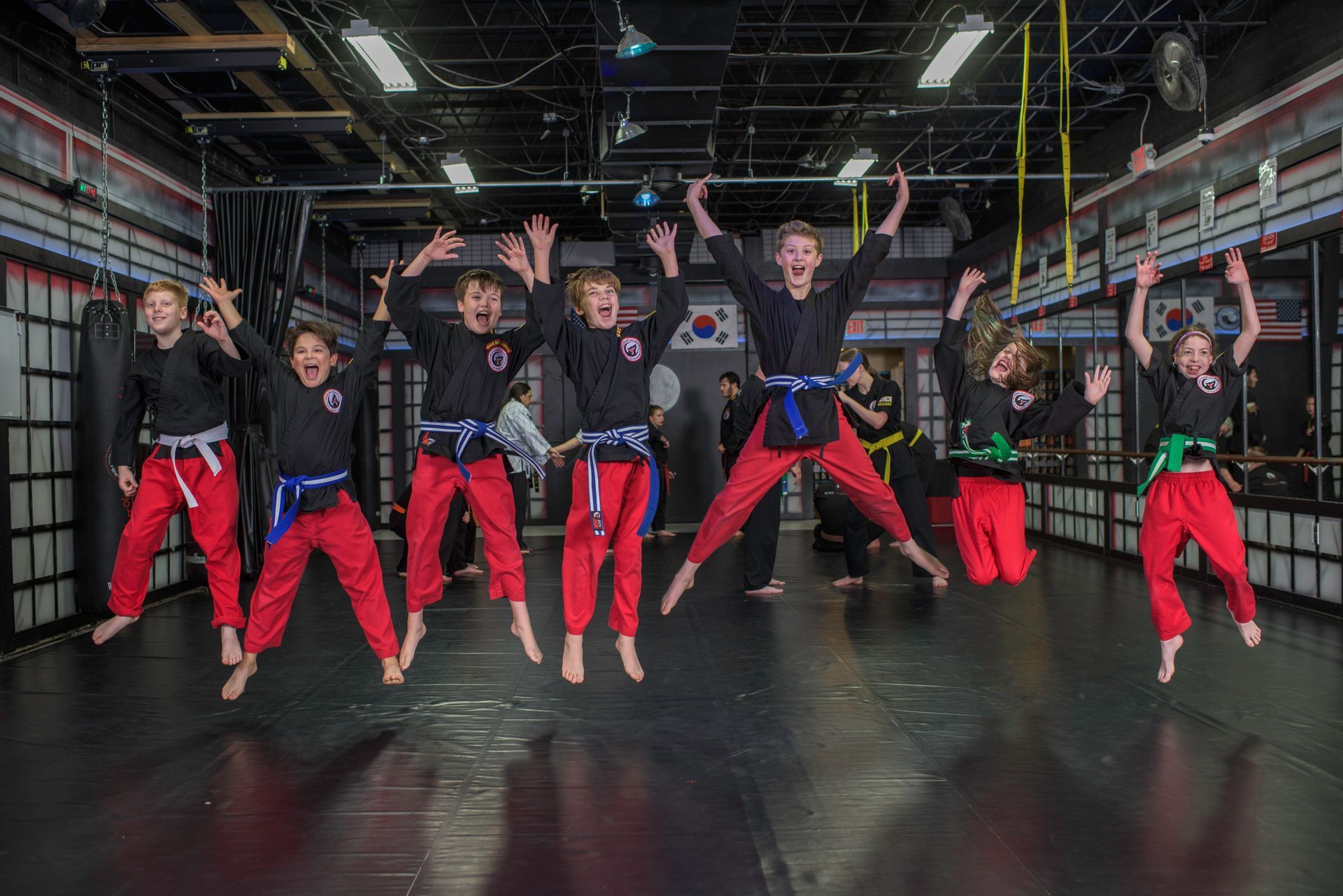 A group of children are jumping in the air in a gym.