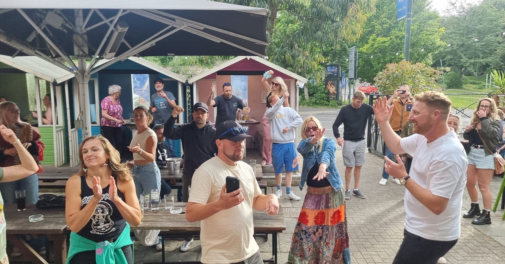 A group of people are dancing in a park.