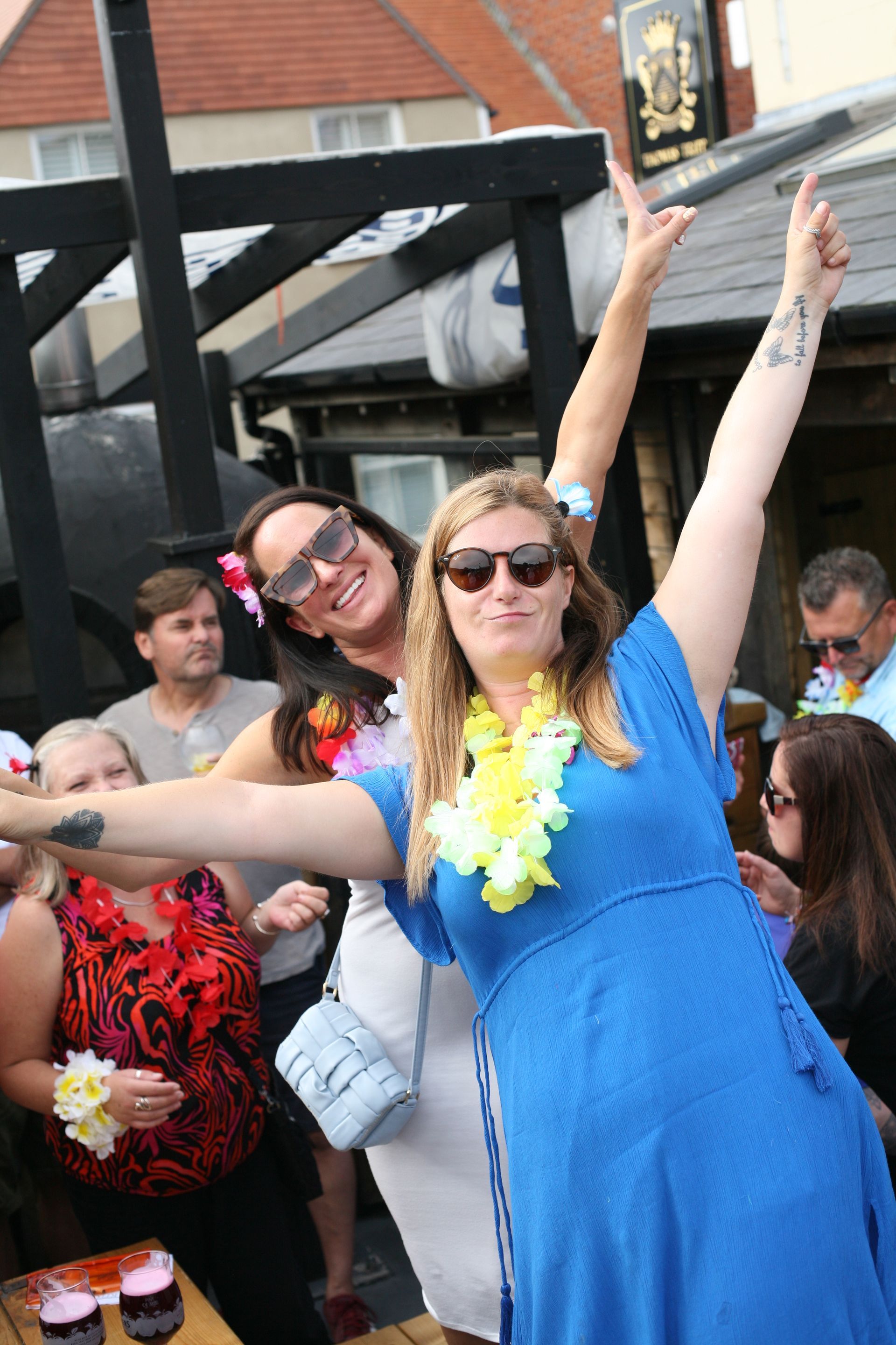 Two women are posing for a picture with their arms in the air.
