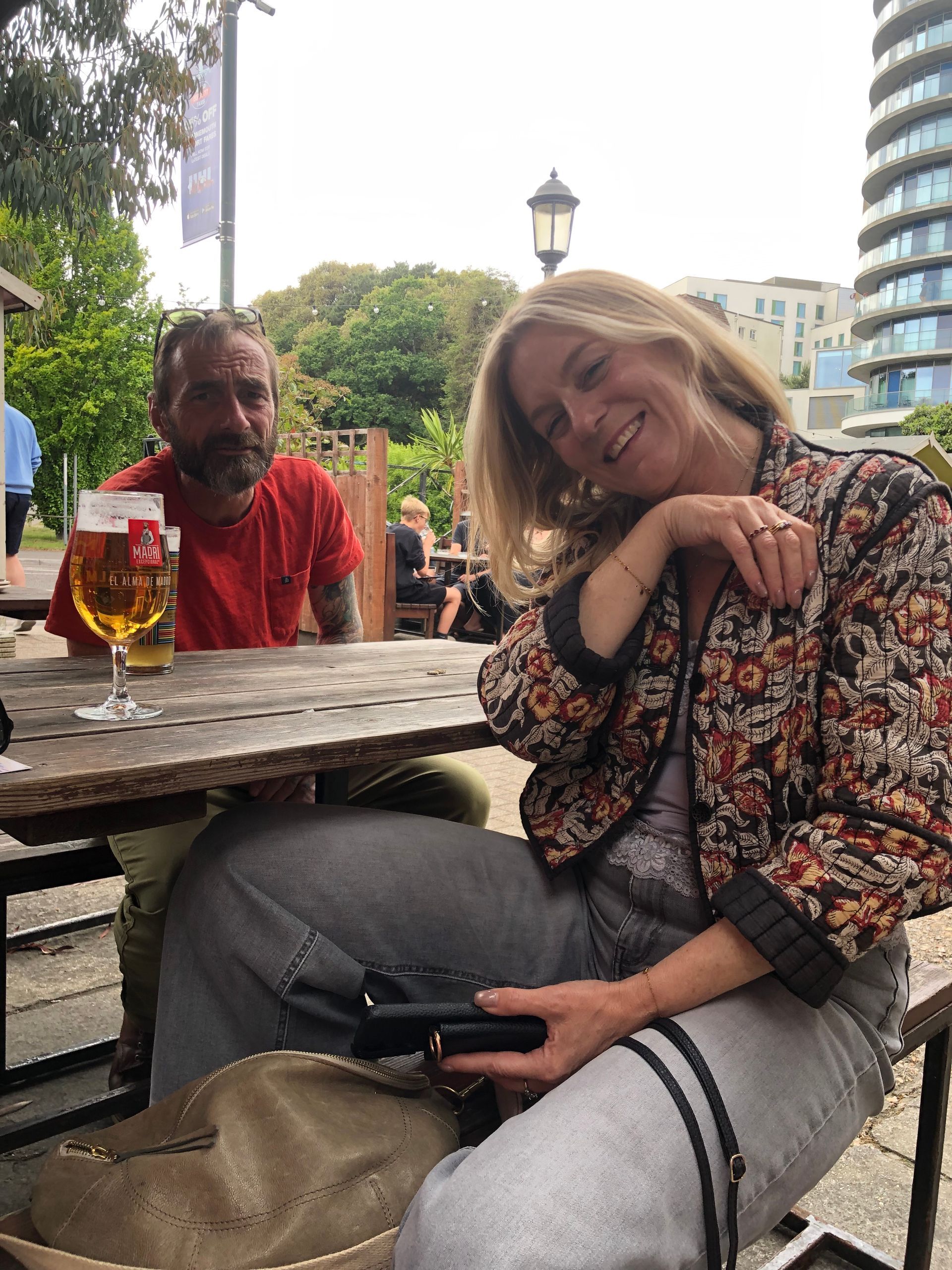 A man and a woman are sitting at a table drinking beer.