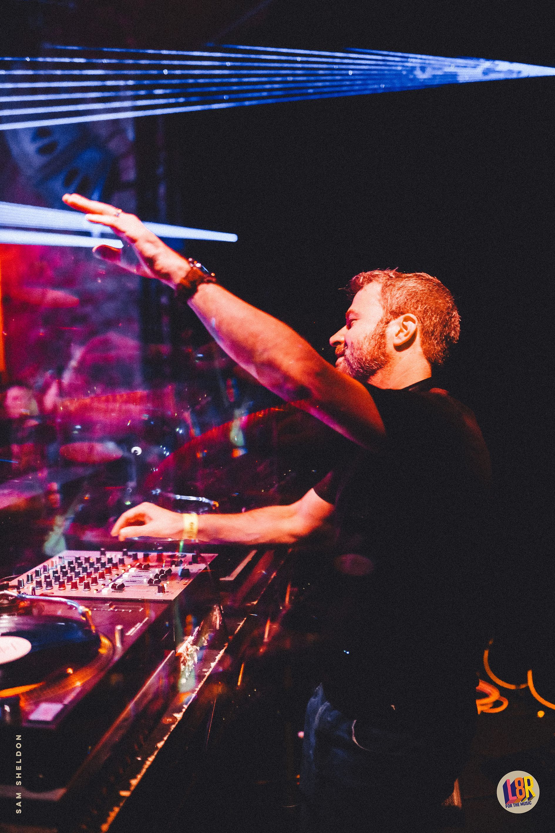 A man is playing a dj set in a dark room