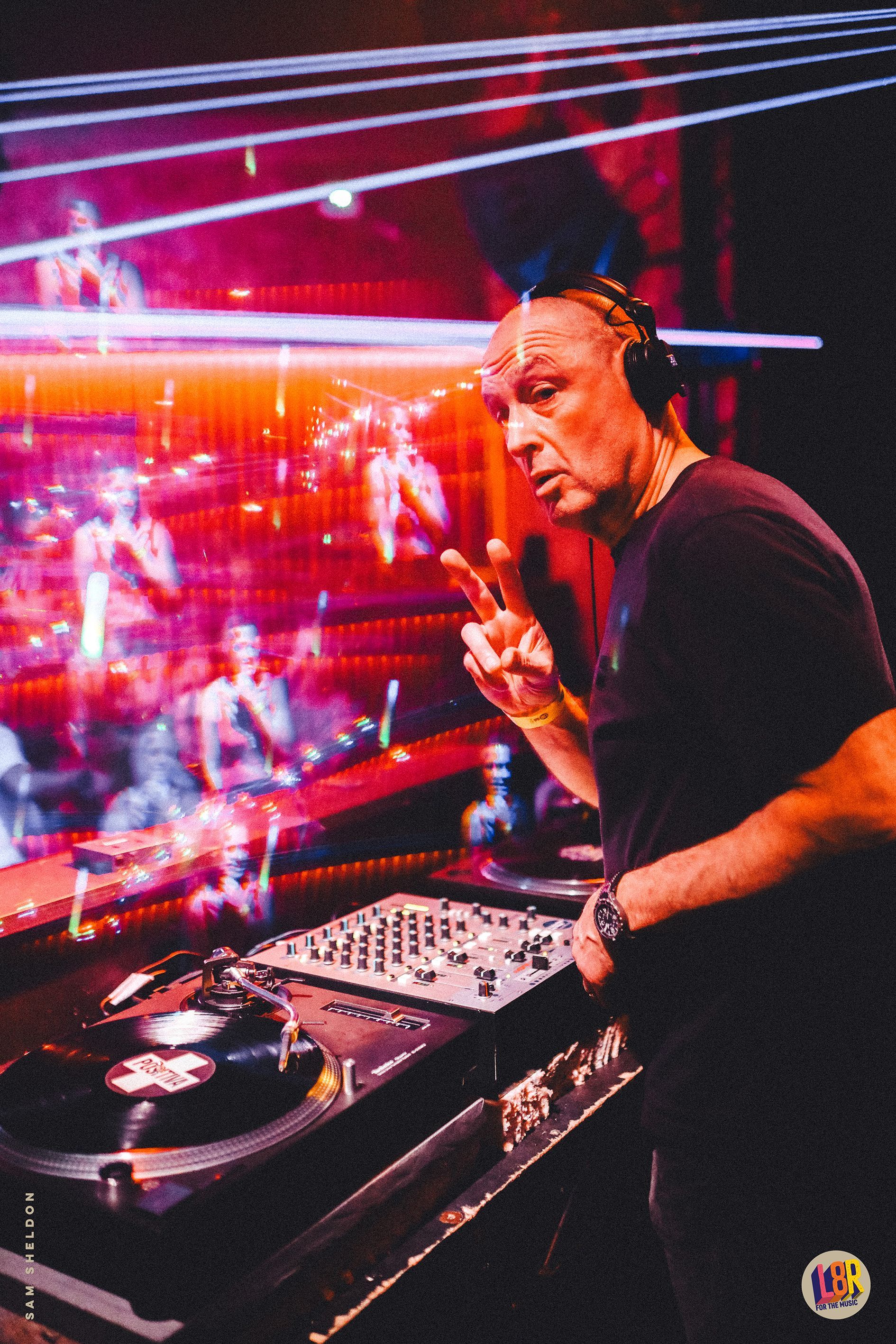 A man wearing headphones is playing music in a dark room