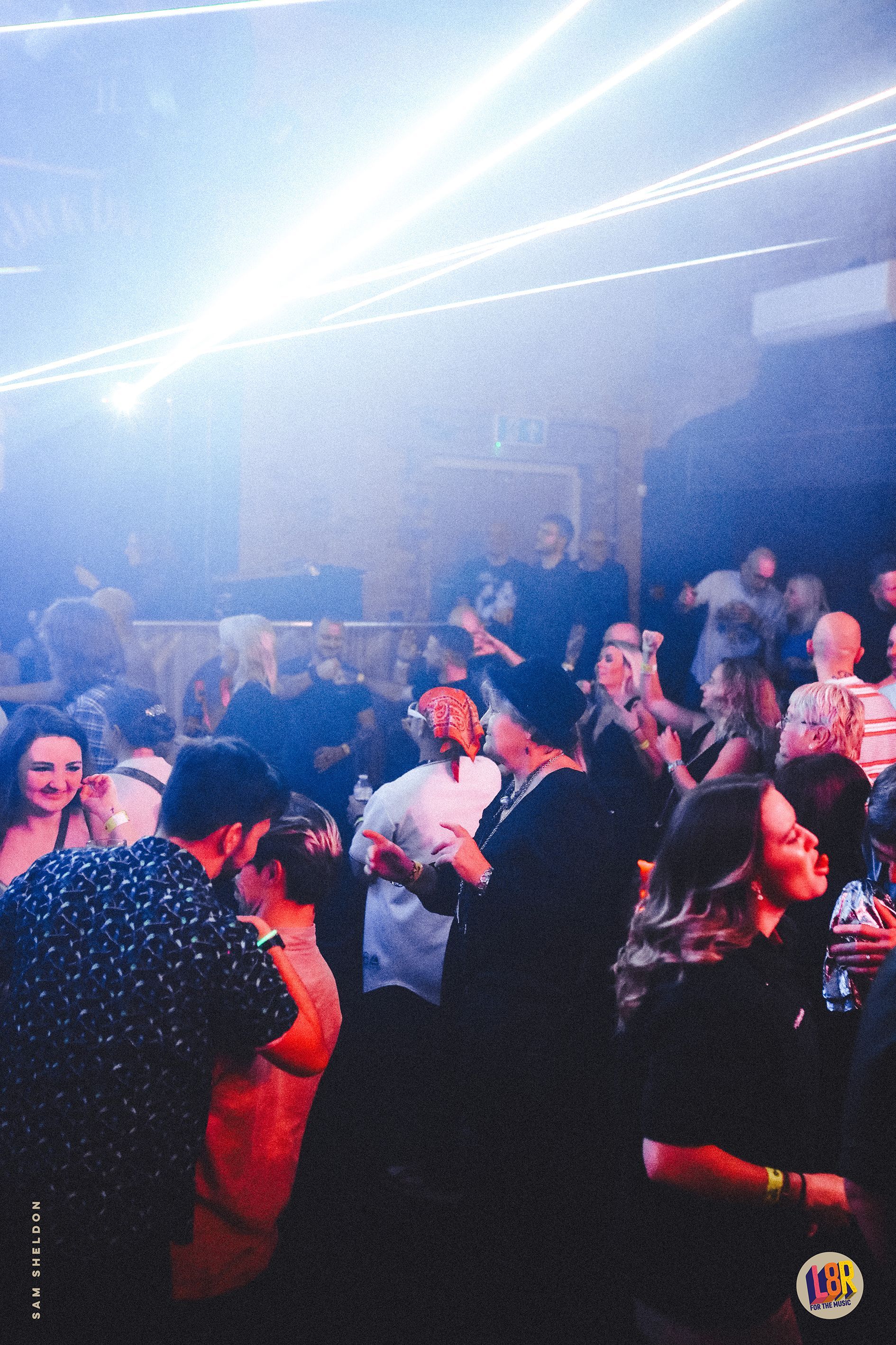 A crowd of people are dancing in a club.