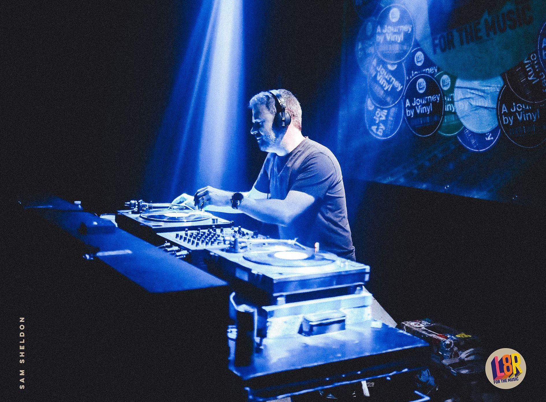 A man is playing a dj set in a dark room