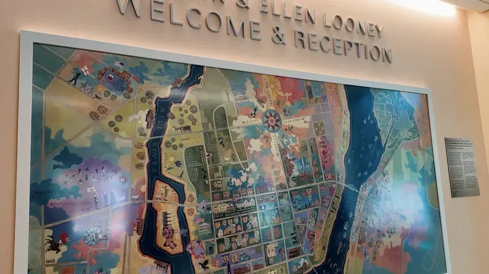 Large colorful wall map with “Welcome & Reception” signage above it in a lobby