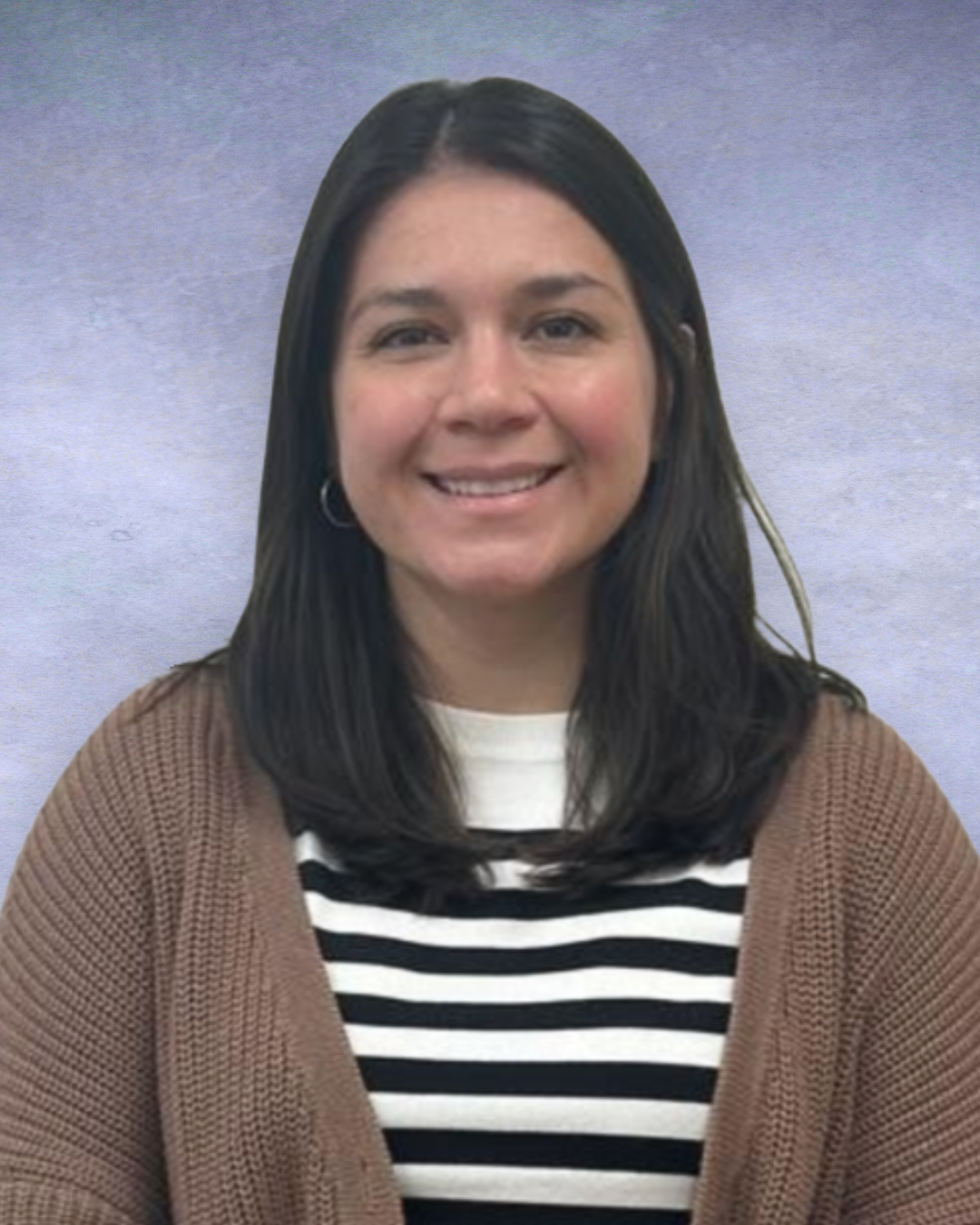 Smiling woman with dark hair wearing a striped shirt and brown cardigan against a gray background