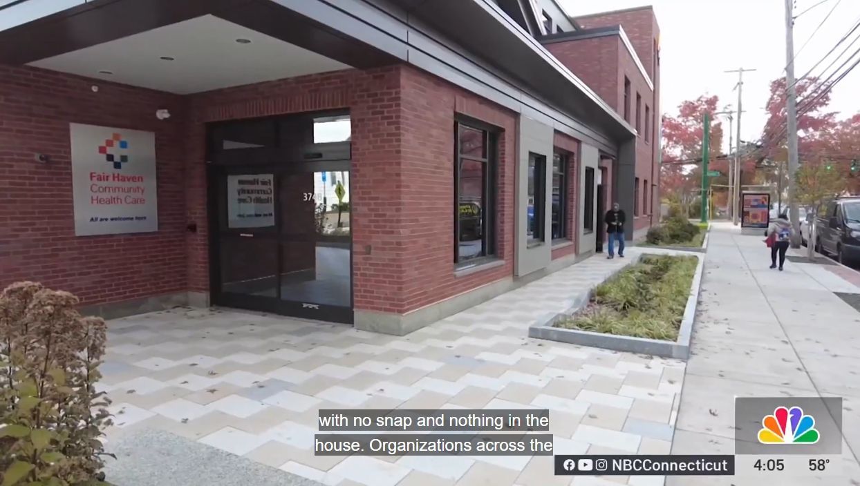 Brick entrance to FHCHC 374 Grand Ave, Building B, with a sidewalk, windows, and a small sign near the door.