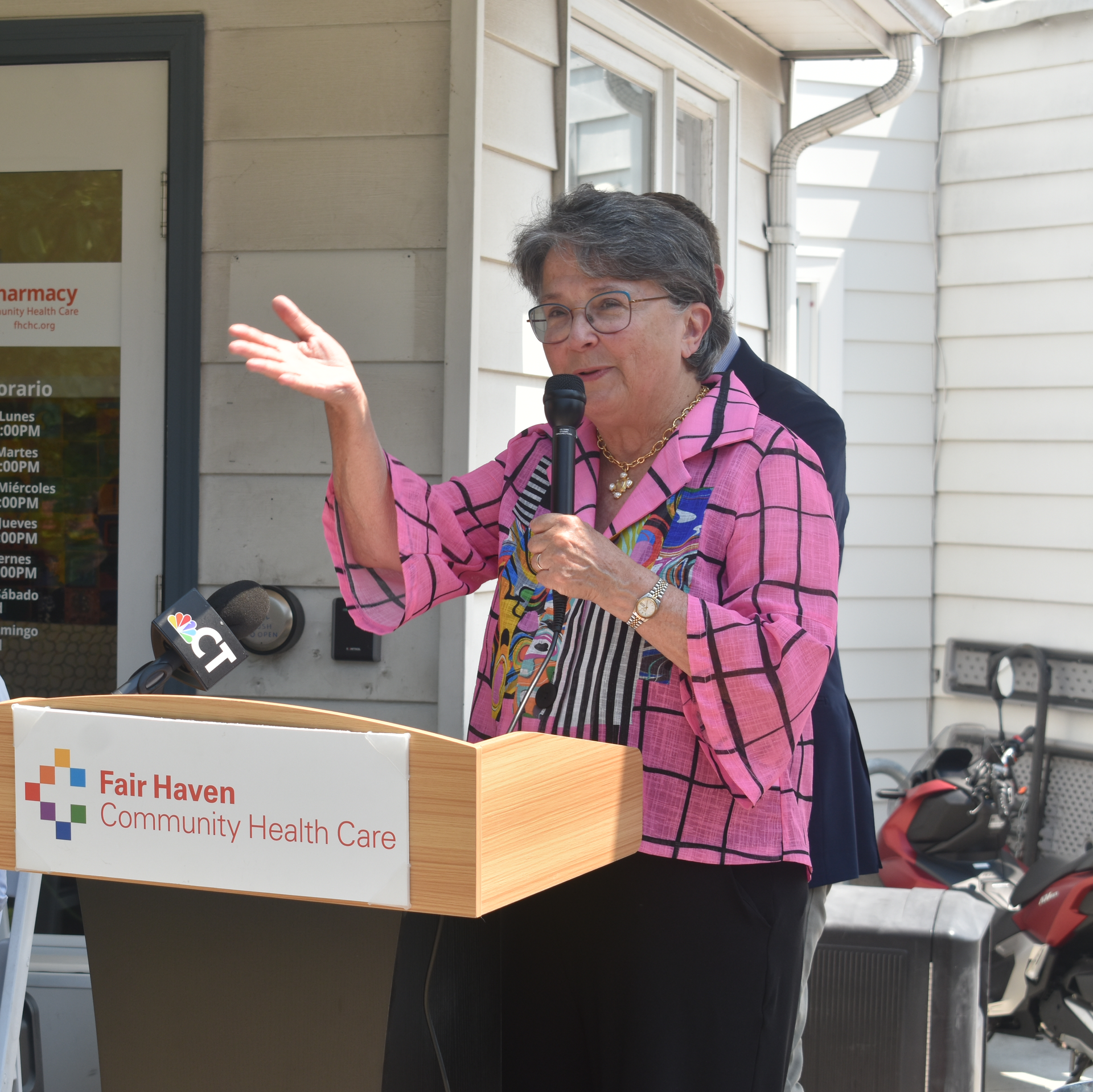 Dr. Suzanne Lagarde giving a talk behind a podium at a press conference.