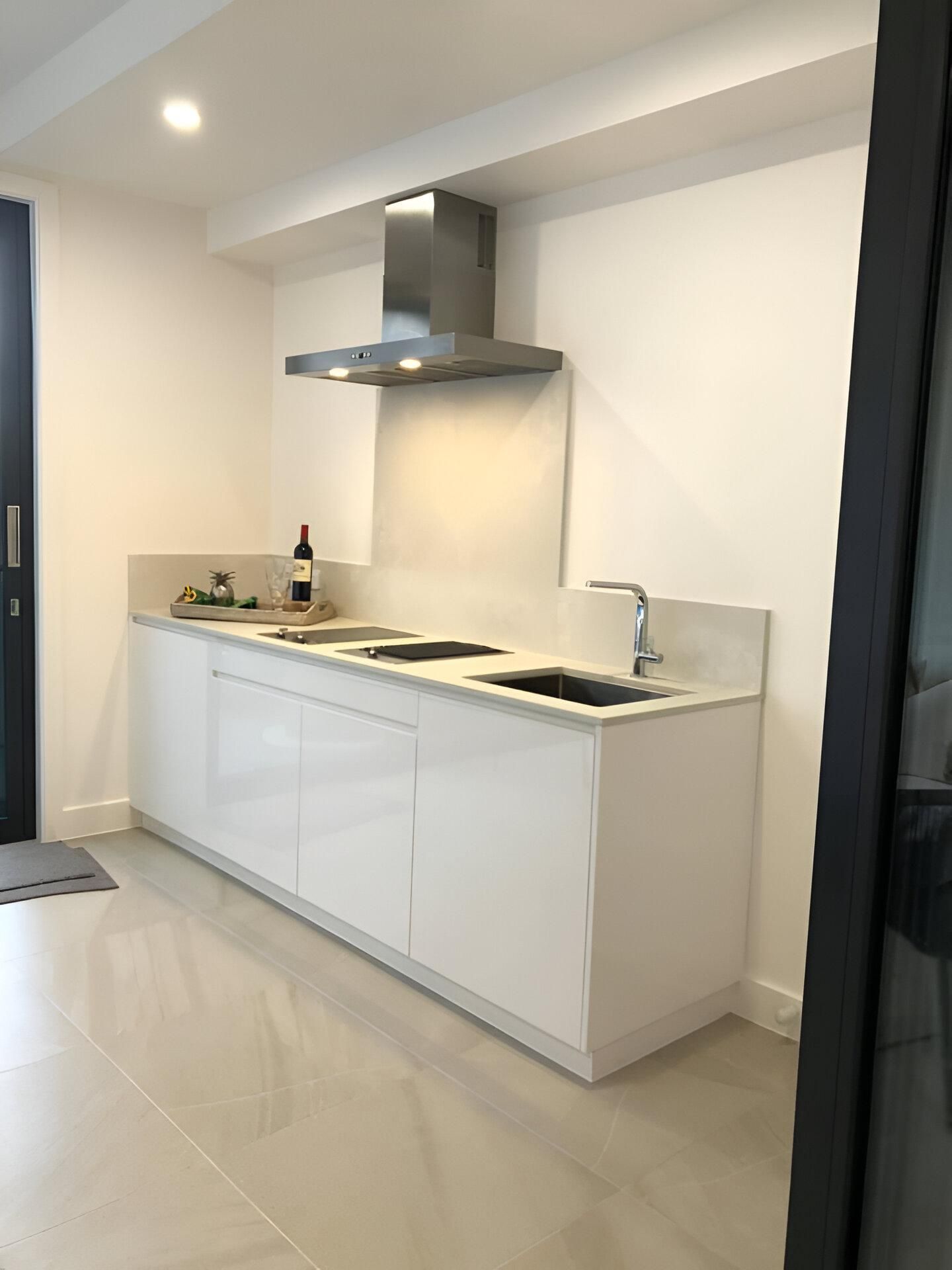 A Kitchen with White Cabinets and A Stainless-Steel Hood — Inovative Interiors In Cardiff, NSW