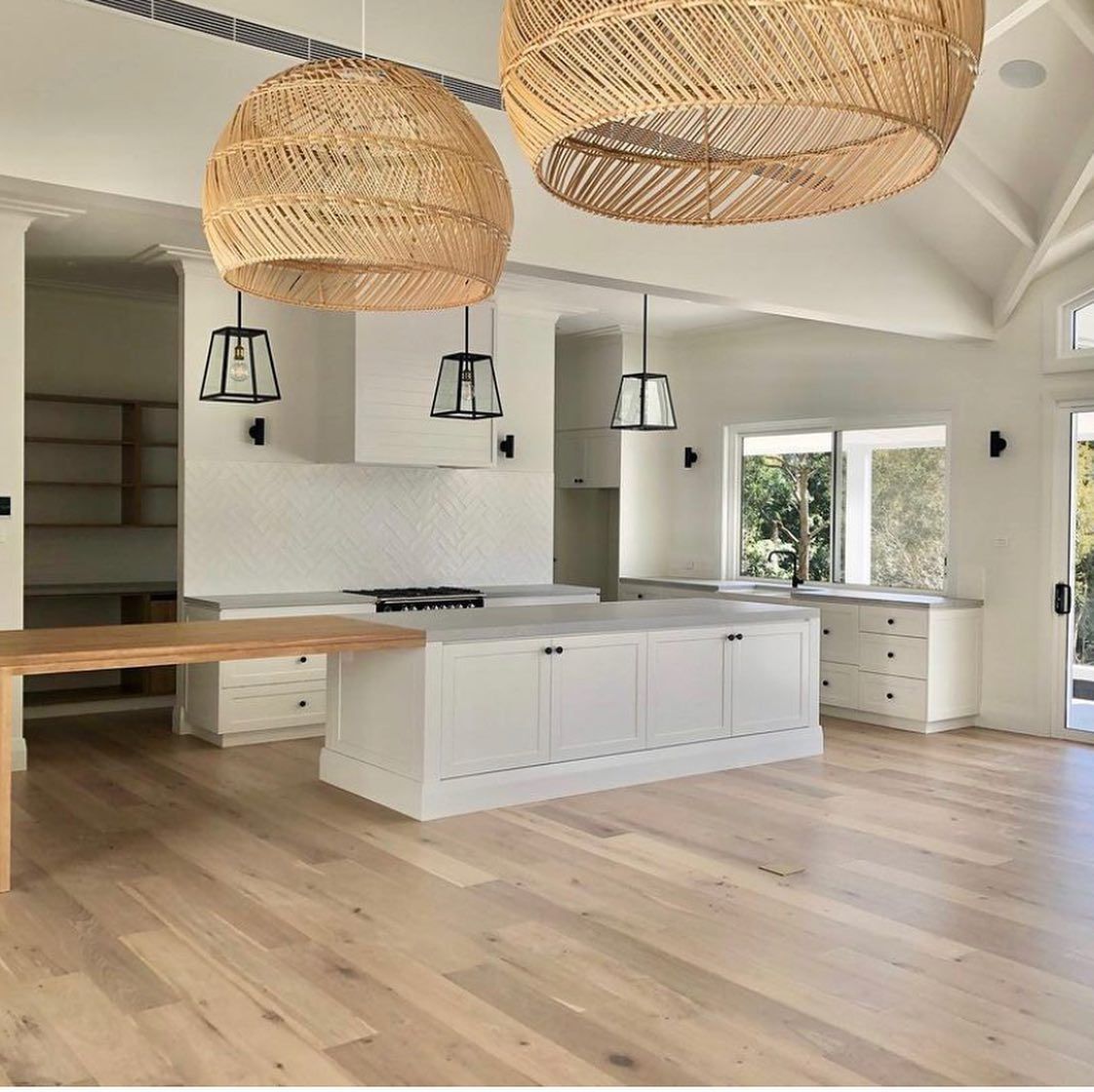 A Kitchen with A Large Island and Wicker Lamps Hanging from The Ceiling — Inovative Interiors In Lake Macquarie, NSW