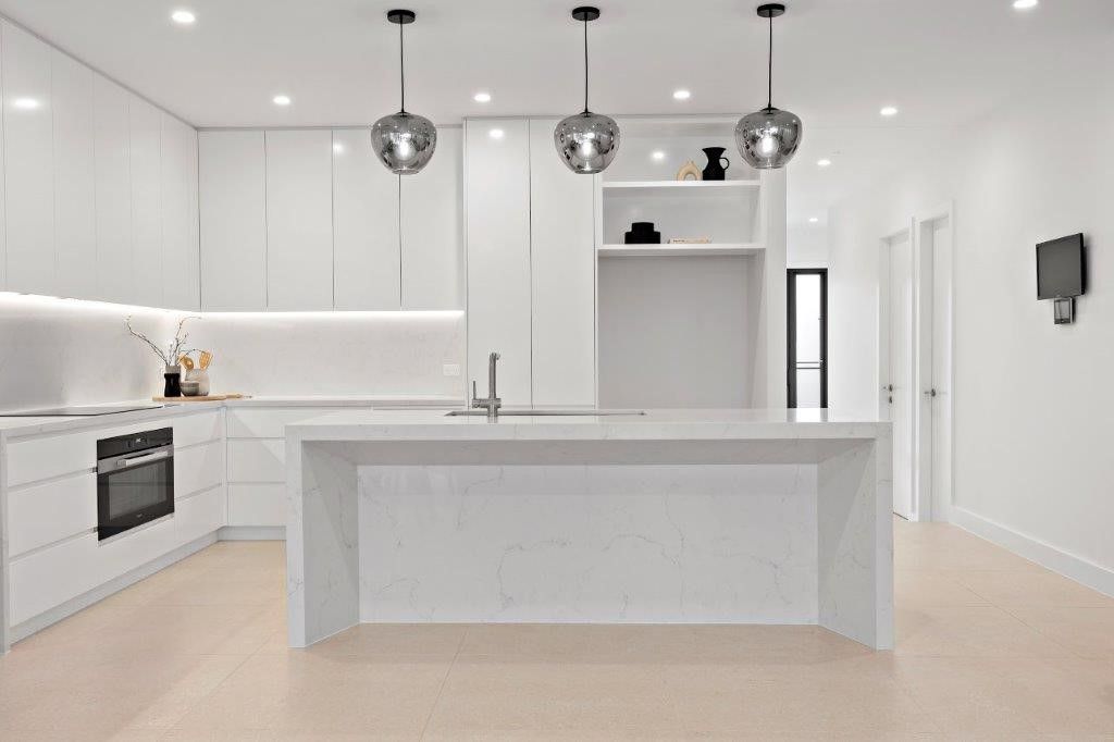 A Kitchen with White Cabinets and A Black Countertop — Inovative Interiors In Cardiff, NSW