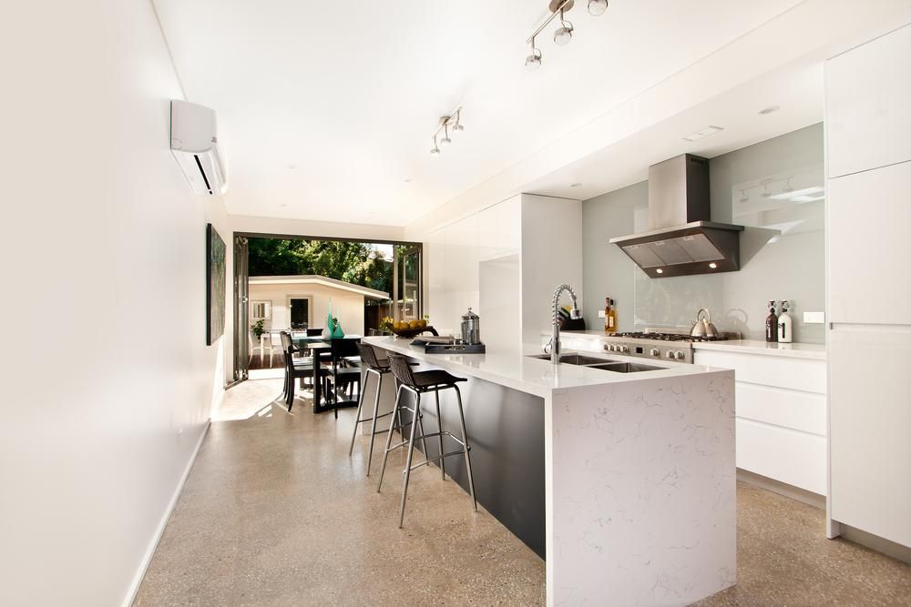 A Kitchen with A Large Island and White Cabinets — Inovative Interiors In Cardiff, NSW