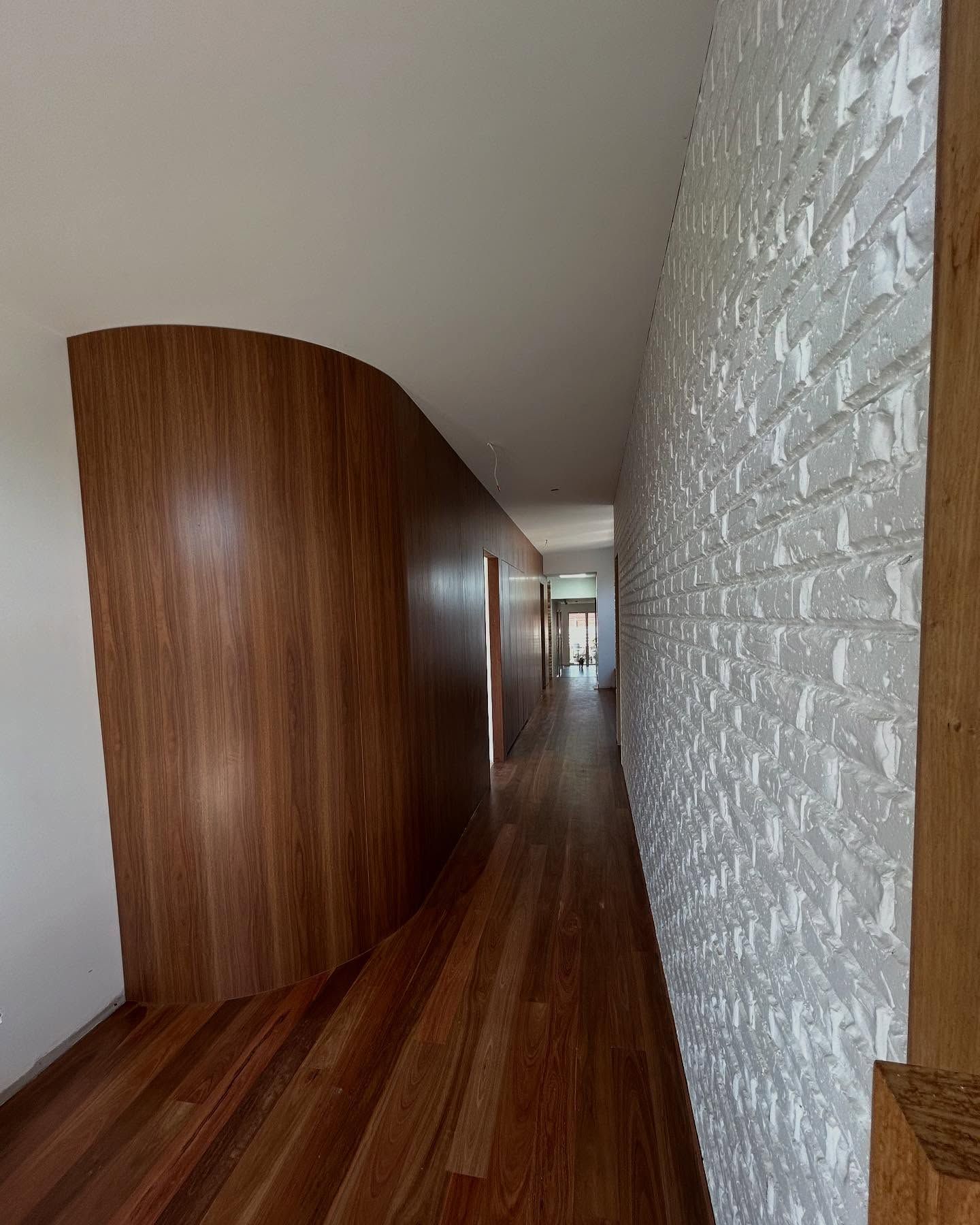 A Large Empty Room with Black Cabinets and Shelves — Inovative Interiors In Cardiff, NSW