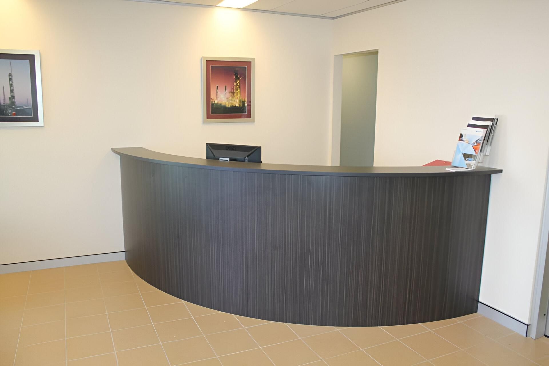A Reception Desk with A Picture on The Wall Above It — Inovative Interiors In Cardiff, NSW