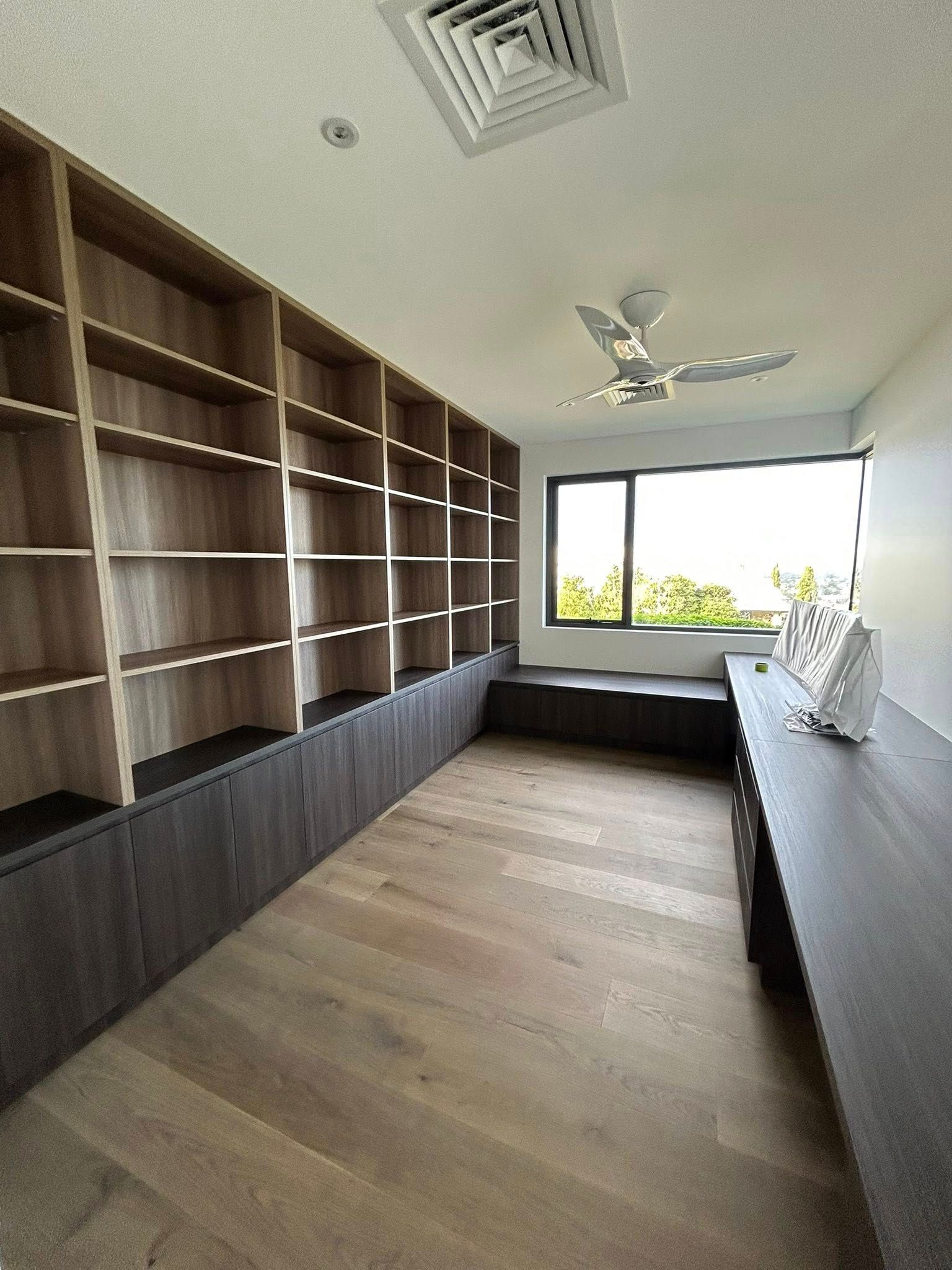 The Inside of An Empty Closet with Wooden Shelves — Inovative Interiors In Cardiff, NSW