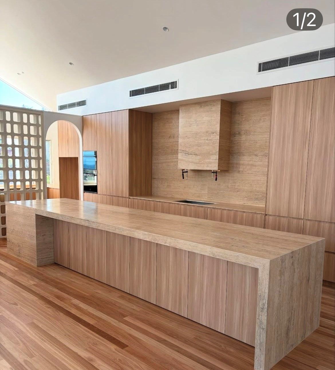 A Walk in Closet with Wooden Shelves and Drawers — Inovative Interiors In Cardiff, NSW