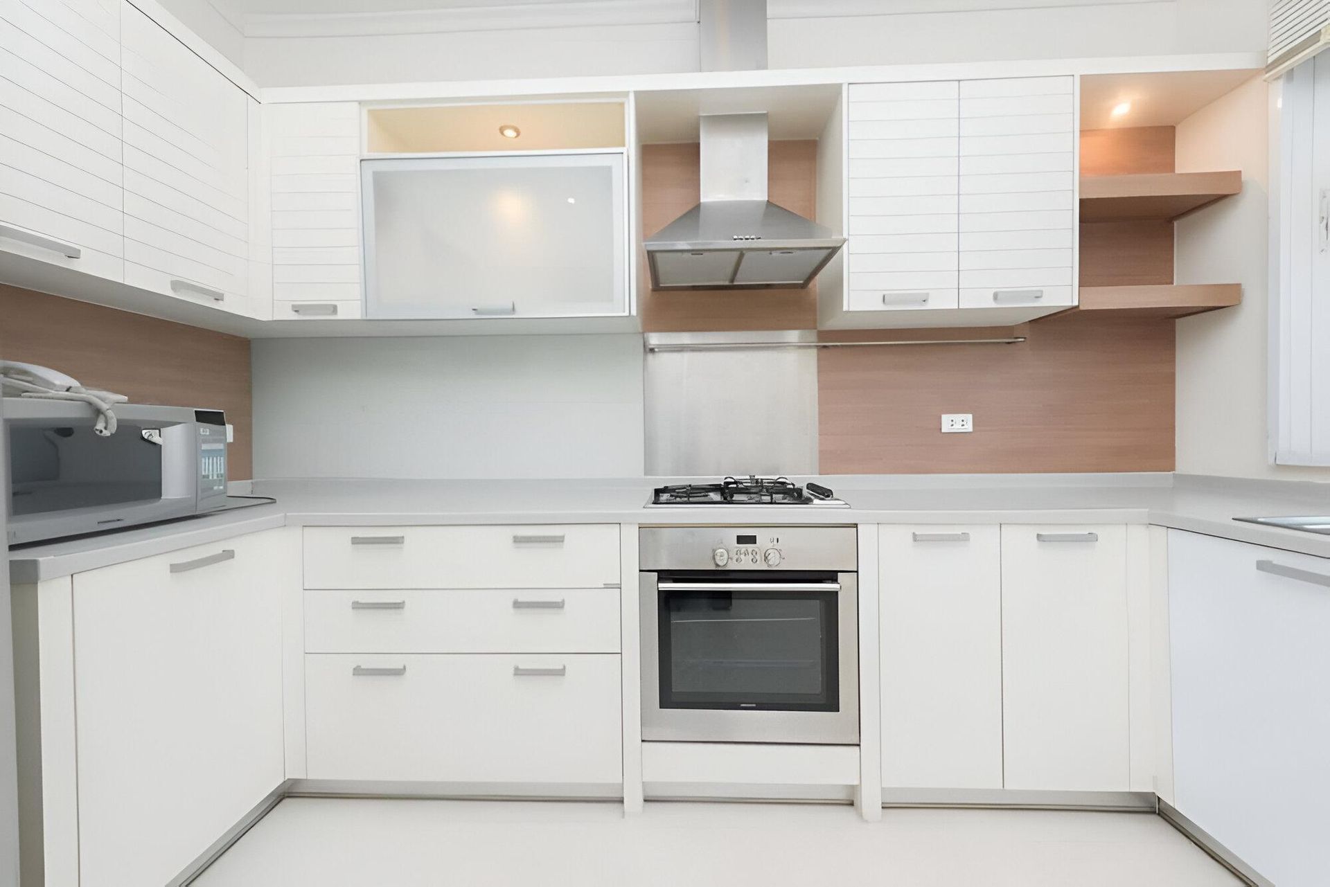 A Kitchen with White Cabinets and Stainless Steel Appliances — Inovative Interiors In Cardiff, NSW