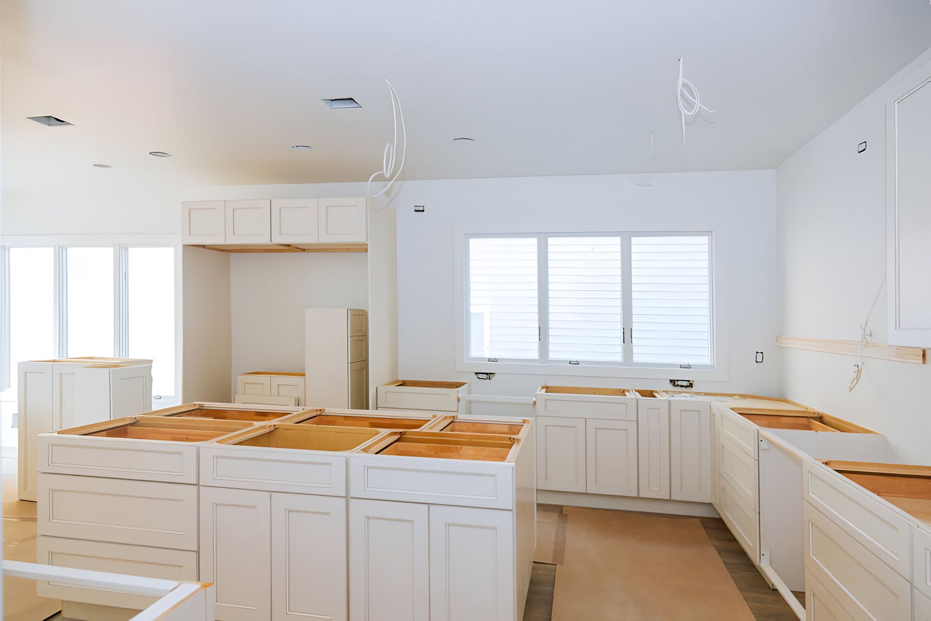 Kitchen under construction with white cabinets and exposed countertops — Inovative Interiors In Cardiff, NSW