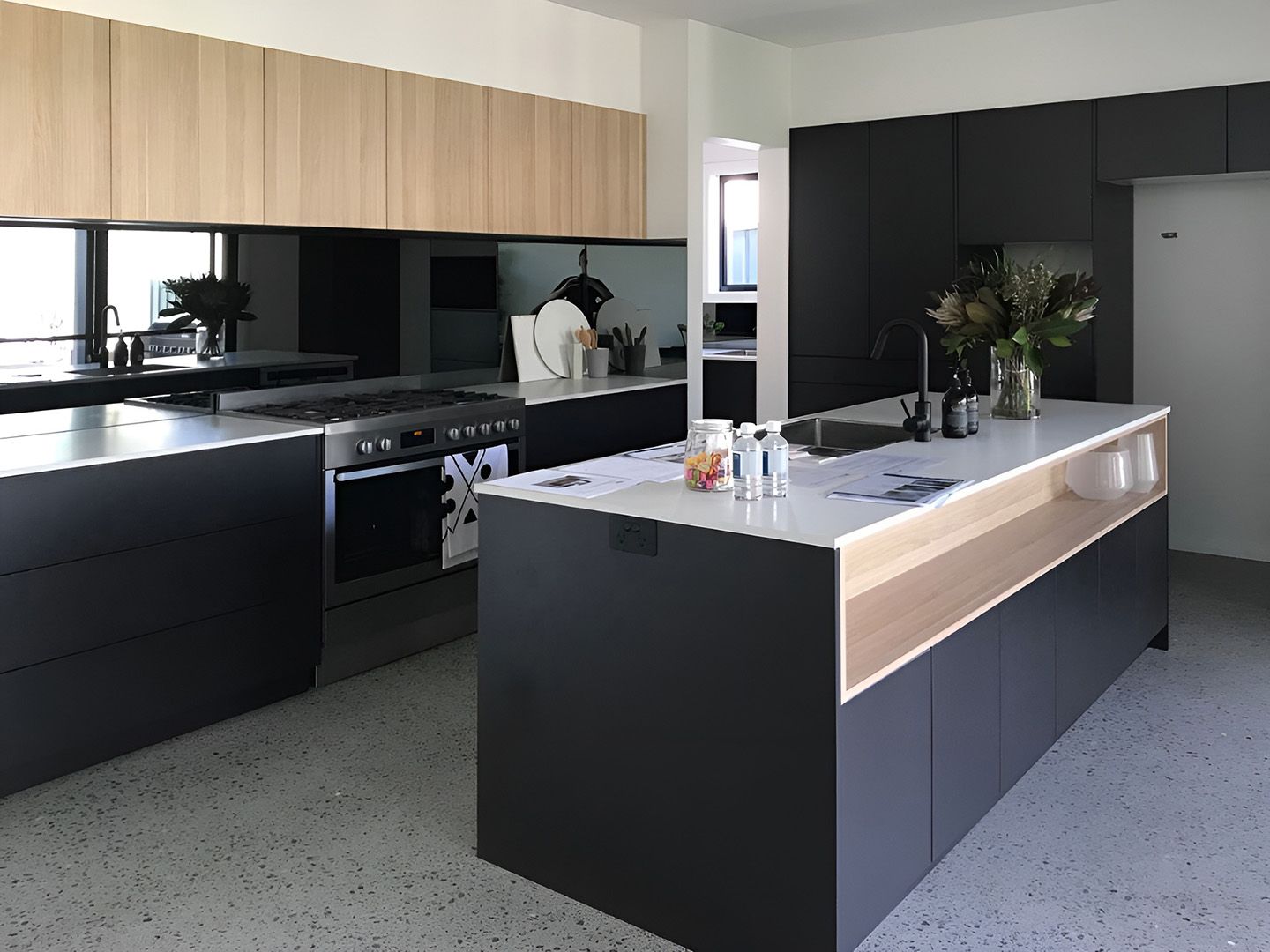 Modern Kitchen Featuring A White Benchtop And Black Island