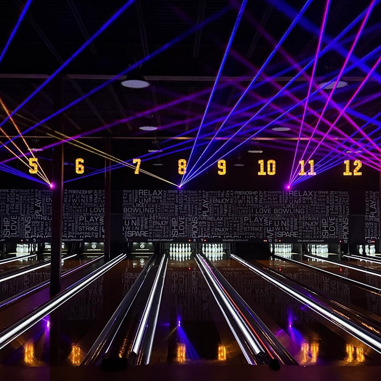 Neon-lit bowling alley with lanes 5–12 under purple and blue laser lights