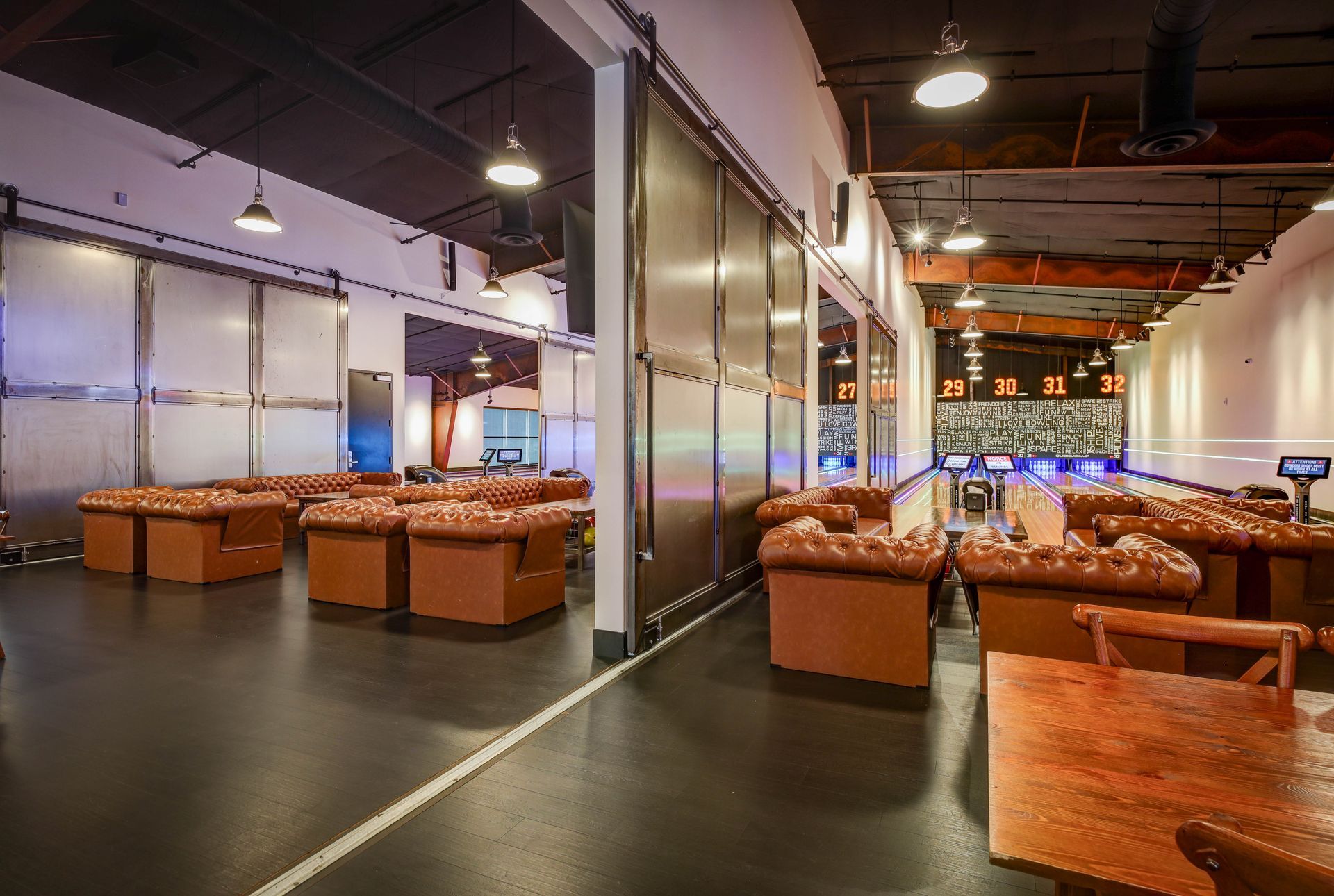 Modern lounge with brown leather seating, glass partitions, and a polished floor in a loft-like interior